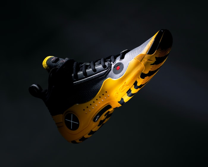 Side view of black and yellow Way of Wade basketball sneakers.